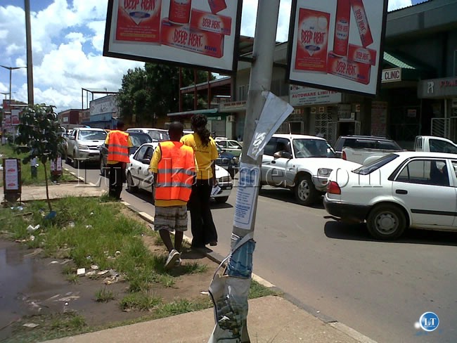 Youth clad in colourful yellow NAREP branded T-shirts during the clean-up of freedom way in Lusaka