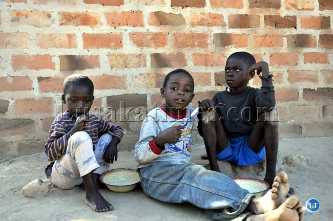 Some brothers eating porridge, a maize meal paste for breakfast