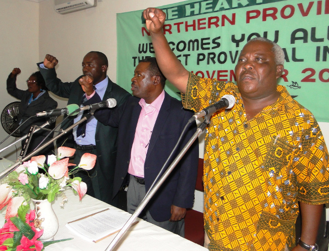 PF Secretary General Wynter Kabimba,Northern Province Minister Freedom Sikazwe and Provincial Treasurer Chomba Chipili shows a party symbol to the delegates after he officiate at the Party Provincial Indaba in Kasama
