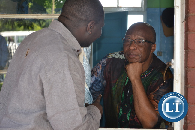 Nevers Mumba talks to his special assistant Raphael Nakachinda through a window at Kitwe Central police Nevers Mumba talks to his special assistant Raphael Nakachinda through a window at Kitwe Central police