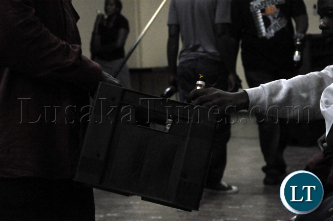 A bar attendant passes some drinks around during the televising of the Zambia Bukina Faso match at a certain Pub in Lusaka.