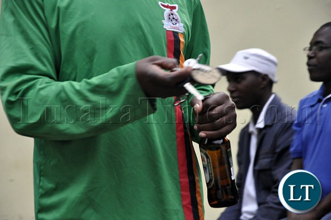 A soccer fan holds a bottle of Mosi lager during the Zambia Bukina Faso match in Lusaka