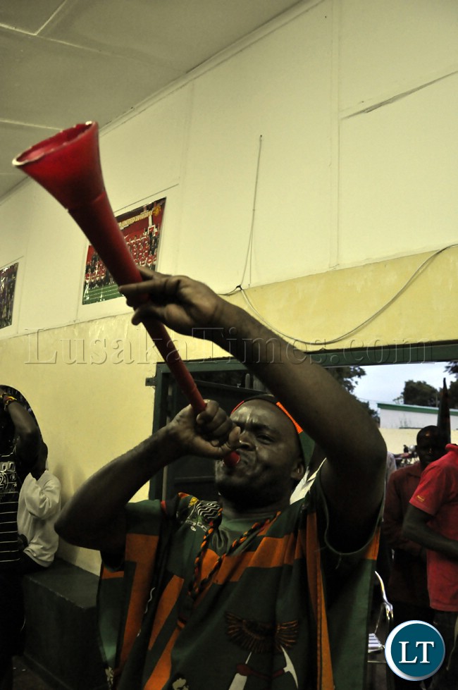A soccer fans blows a vuvuzela (trumpet) during the Zambia Bukna Faso match.