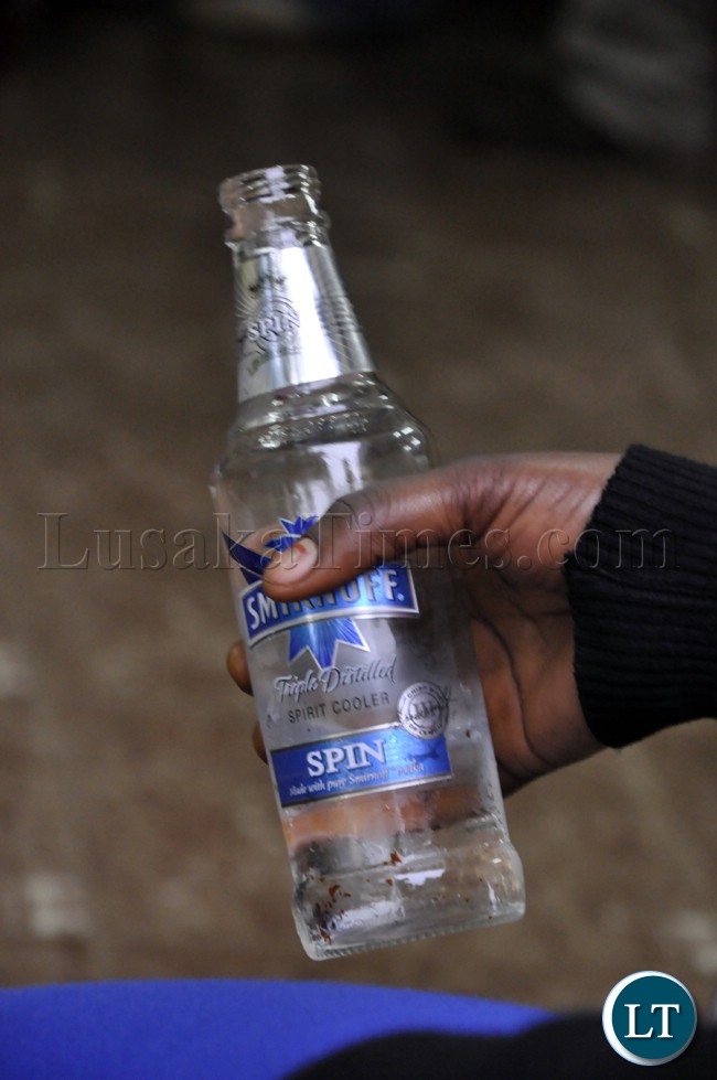 A woman holds a bottle of an alcoholic beverage during the Zambia Bukina Faso match in Lusaka