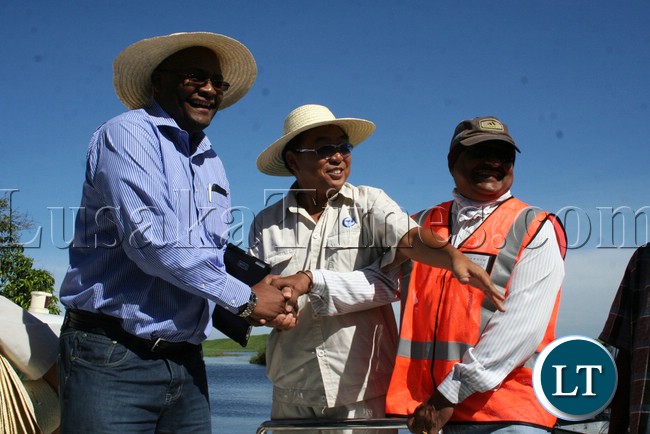 Western Province Permanent Secretary Emmanuel Mwamba shaking hands with Rankin Resident Engineer Ramesh Suryawanshi (r) while AVIC site Manager Liu Zhenjie showing directions during the visits of the bridges on Mongu