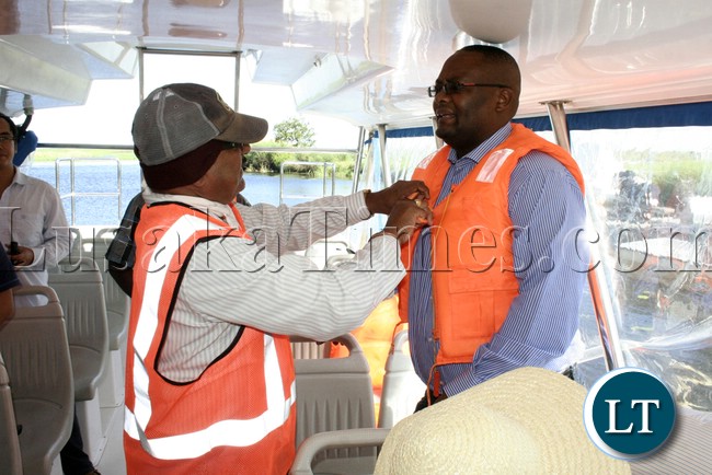 Rankin Resident Engineer Ramesh Suryawanshi helping to dress Western Province Permanent Secretary Emmanuel Mwamba with the life jacket during the visits of the bridges on Mongu –Kalabo Road