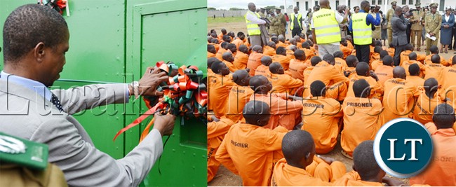 HOME Affairs Minister Edgar Lungu cuts a ribbon during commissioning of newly built Mwembeshi Maximum security prison in Mumbwa district .On the right, are some of the inmates waiting to be addressed by Mr Lungu