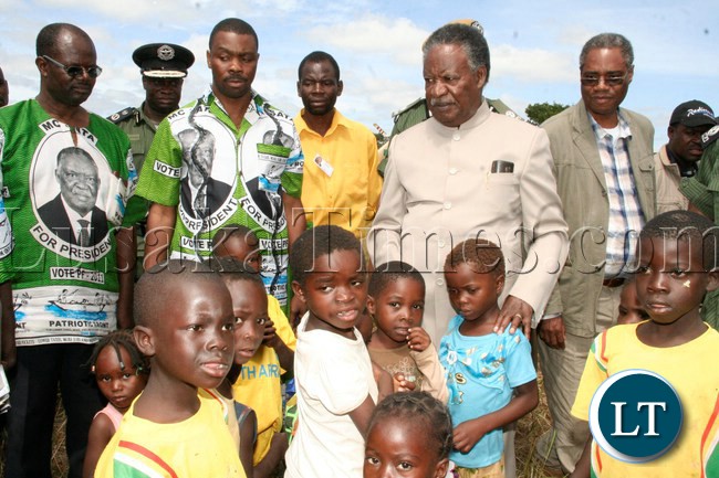 President Sata with little children , and to the far left is PF Candidate for Kapiri Eddie Musonda, Central Province Minister Phillp Kosamu and Commerce Minister Emmanuel Chenda in Ngambwe area during his campaign tour for the Kapiri by-elections in Kapiri, April 13, 2013.