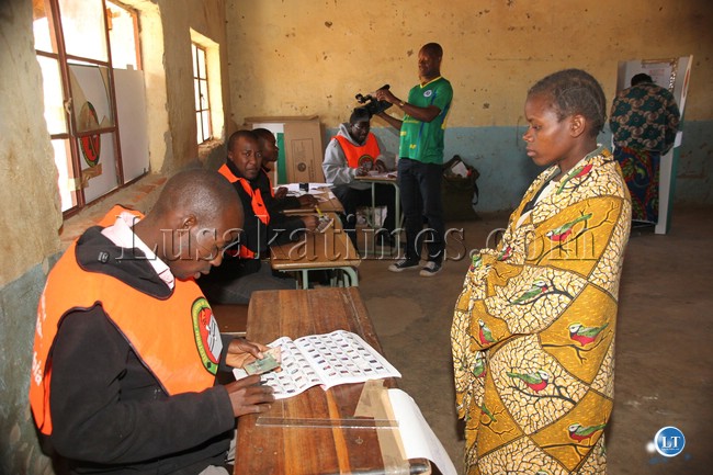 polling assistants verifying the details of a voter at omelo mumba basic school in Katete district yesterday