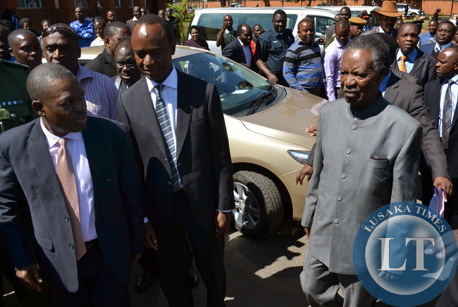 President Michael Sata is accompanied by Justice Minister Wynter Kabimba (left) and Lusaka Mayor Mulenga Sata as he left the Lusaka High Court
