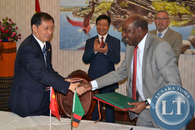 Finance Minister Alexander Chikwanda shakes hands with Chinese Vice Minister of Commerce Li Jinzao (left) after signing various agreements in the presence of Vice President Guy Scott and Chinese Vice President Li Yuanchao (second from left) look on at Government House in Lusaka