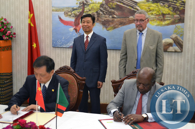Finance Minister Alexander Chikwanda and Chinese Vice Minister of Commerce Li Jinzao (left) sign various agreements as Vice President Guy Scott and Chinese Vice President Li Yuanchao look on at Government House in Lusaka