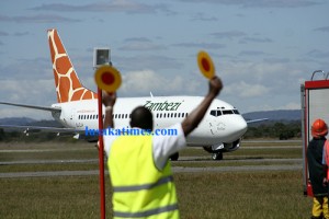 a-ground-air-traffic-controller-signaling-to-pilots-who-delivered-the-boeing-737-500-aircraft-to-zambezi-airlines