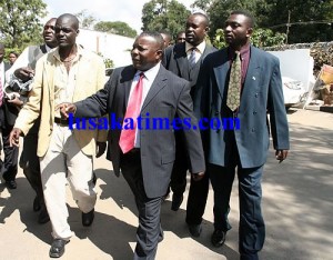 Former Patrotic Front secretary general Edward Mumbi is ecorted to his car after addressing a press conference in Lusaka