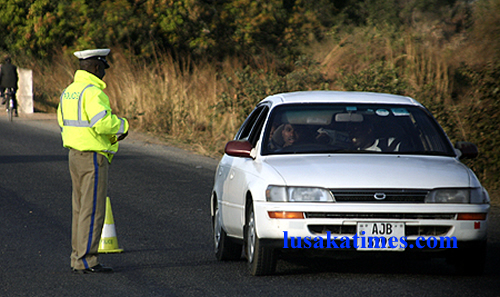 File: A traffic policeman attending to a motorist at a roadblock near Chikankata in Mazabuka.