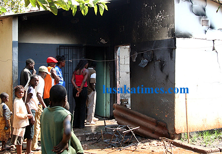 Curious people inspect a gutted house in Lusaka's Chelstone area at the weekend