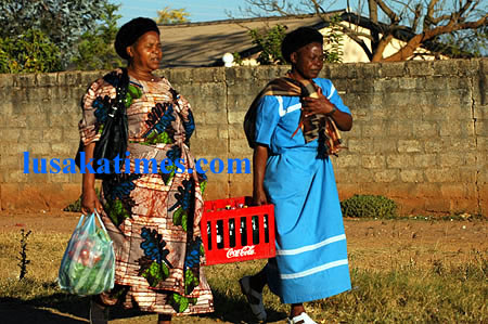 Two women dragging a crate of soft drinks to a kitchen party in Lusaka at the weekend