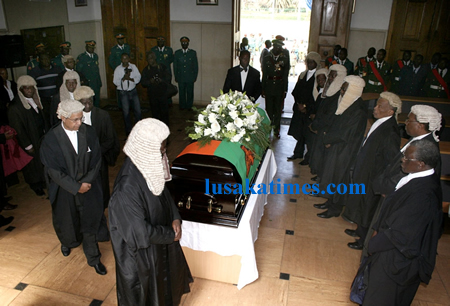 Lawyers and other members of the judiciary surround the coffin for the late John mwanakatwe