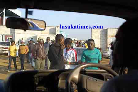 A driver watching soccer fans coming out of Nkoloma stadium after the match between Green Buffaloes and Red Arrows