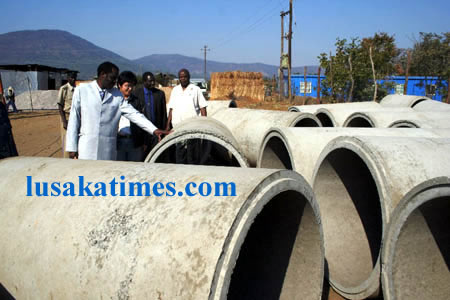 Eastern Province Minister Isaac Banda ( l) inspects culverts in Katete made by Hua Chang construction which has been engaged to repair feeder roads in Katete and Chipata districts