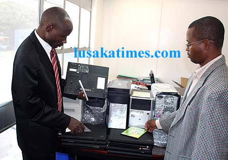 Police acting Zambia police spokesperson Moses Suwali (r) inspect pirated computer softwares confiscated from a Chinese trader in Lusaka