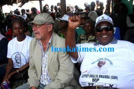 Patrotic Fron Kasama central parliamentary candidate Geoffrey Mwamba waves his party symbol at the Kusefya Pangwena traditional ceremony with Guy scoot and Mumbi Phiri on the left