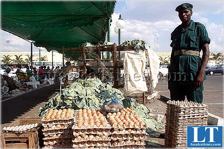 An officer from the Zambia National Service stands beside agricultural produce during an independence day event at Arcades shopping centre in Lusaka