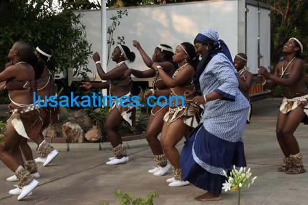 Juxtaposed...An old lady tries to catch up with the dancing pace of young women from Kasane in Botswana who performed during the Botswana national day in Lusaka