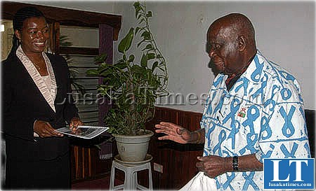 Dr Kaunda about a receive a booklet on environmental management from tourism minister Catherine Namugala. Dr kaunda leads a special committee on environmental management in Zambia