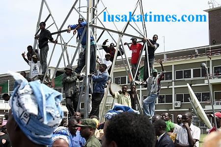 MMD cadres climb the flood light poles to catch a glimpse of of him when he arrived from Cuba