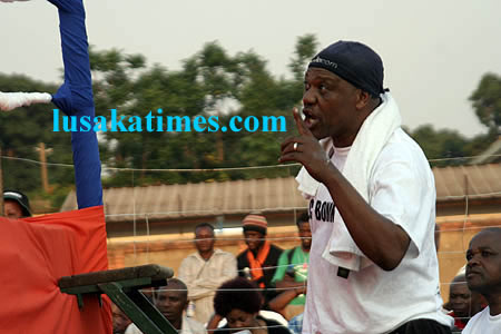 A south African boxing coach shouting instructions to his boxer who was being 'pounded' in the ring