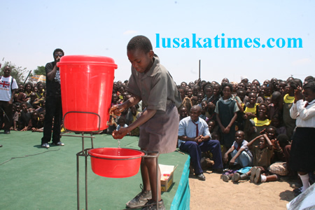 A Chawama basic shool pupil, Stephen Sichilima demostrating how to keep himself health by using water and soap during the Lusaka district risk reduction sensitisation programme at Chawama basic school programmes