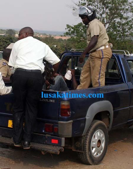 Police officers bundling drunken and unruly youths into a van in Kitwe