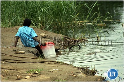 A young boy tries to draw water from the crocodile infested Kafue river because of lack of bore holes and other good sources of clean and adequate water. A young boy tries to draw water from the crocodile infested Kafue river because of lack of bore holes and other good sources of clean and adequate water.