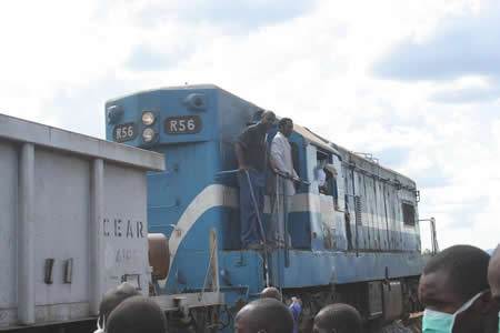 Eastern Province Minister, Isaac Banda (in suit) and Chipata/Mchinji railway project engineer, Ernest Silwamba, on the locomotive engine that brought ballast stone to Chipata from Malawi.