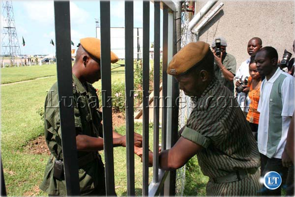 scribes 3 Journalists assigned to cover the departure of president Rupiah Banda to Angola at Lusaka International Airport were yesterday blocked by police officers who claimed that they were instructed to keep away the media because the departure was private. Above, police officers unlock a gate to let the journalists in after senior State House officials intervened