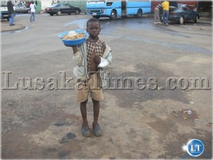 Helping his parents make ends meet-A five year old boy selling groundnuts at Mwaiseni bus station in Chingola.