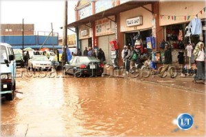 Floods in the Kamwala second class trading area. Shoppers have to wear gumboots or wade in the pools of water to access shops.