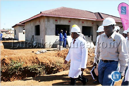 Local government and housing minister Eustarkio Kazonga inspect the ZAIN Zambia hosuing compound for winnders of the SMS promotion in Lusaka