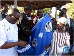MMD vice treasurer Mwansa Mbulakulima gives chitenge materials to former Patriotic Front members who defected to the ruling party on the Copperbelt.