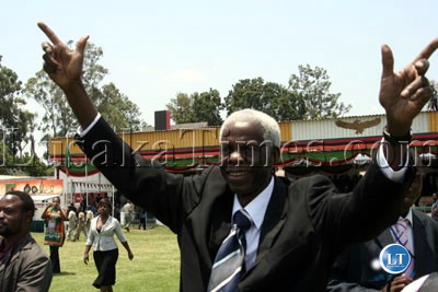 Former Agriculture Minister Mundia Sikatana brandishes the ruling MMD party symbol during Independence Day celebrations - Copy - Copy