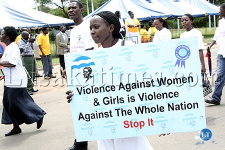 A woman carries a lacard during launch opf the 16 days of activism against gender based violence in Lusaka.