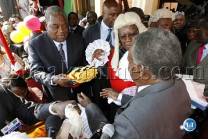 President Michael Sata receives instruments of power from outgoing President Rupiah Banda as Chief Justice Ernest Sakala looks on at the inauguration ceremony at the Supreme Court in Lusaka
