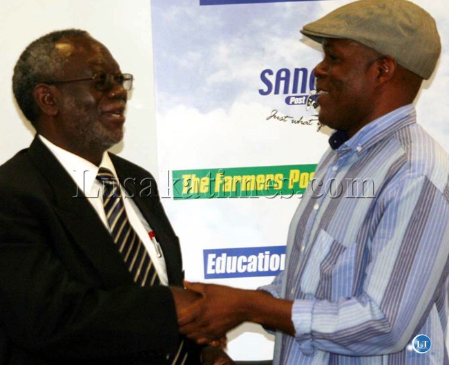 Information Minister Fackson Shamenda (l) and Post newspapers owner Fred Mmember clench hands after a meeting in Lusaka