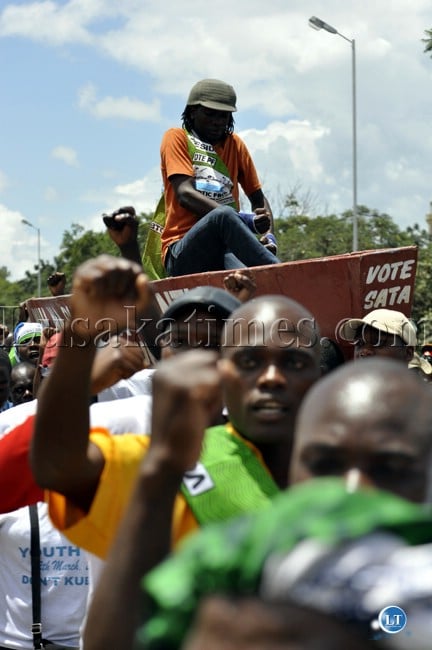 Patrotic Front youths display symbols of their party during the Youth day march past Patrotic Front youths display symbols of their party during the Youth day march past