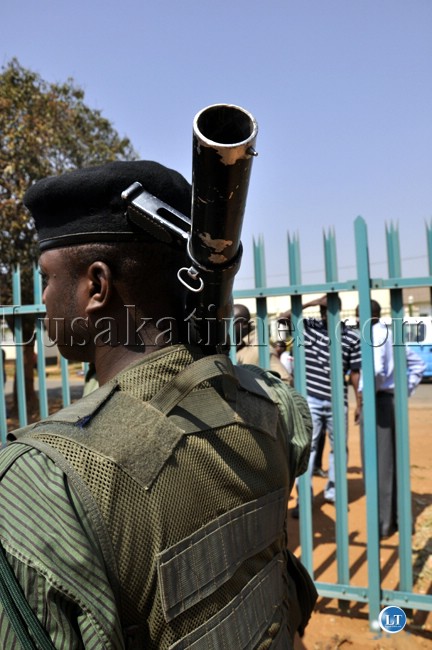 A policeman carries a teargas long range gun outside the Lusaka magistrate court