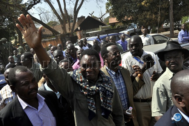 Hakainde Hichilema waves at supporters before he was taken to the Lusaka magistrate court