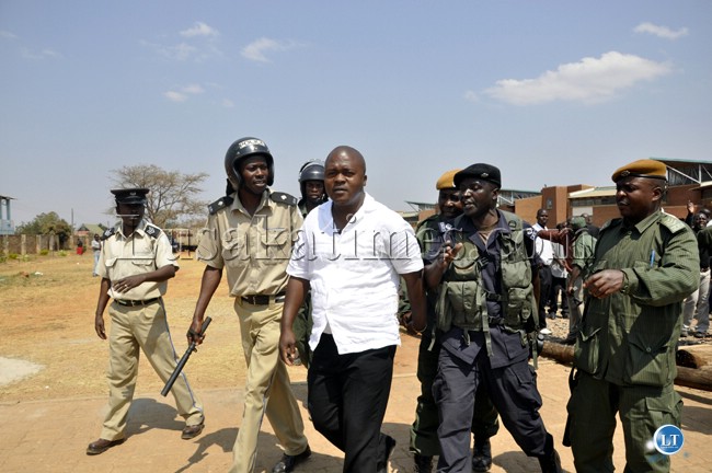 Police officers eject a PF member from the Lusaka magistrate court who was fanning trouble on UPND members