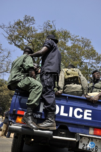 Police officers escort UPND leader Hakainde Hichilema to the Lusaka magistrate court