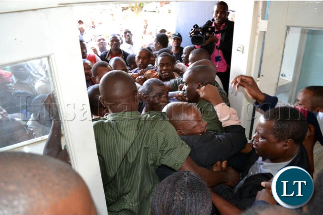 Police officers try to prevent suspected UPND cadres from entering Woodlands police station in Lusaka